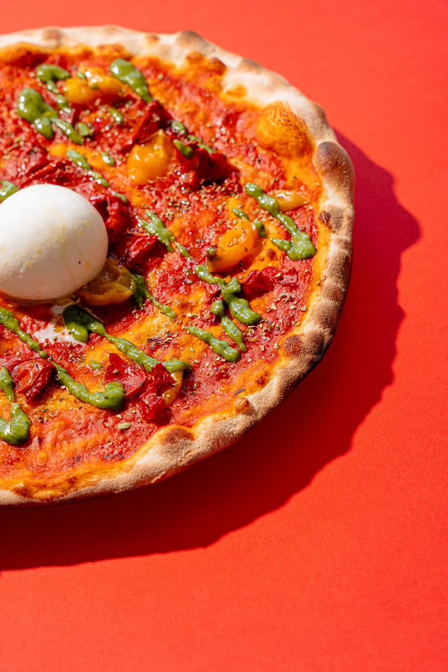 Pizza con pomodoro e burrata su fondo rosso