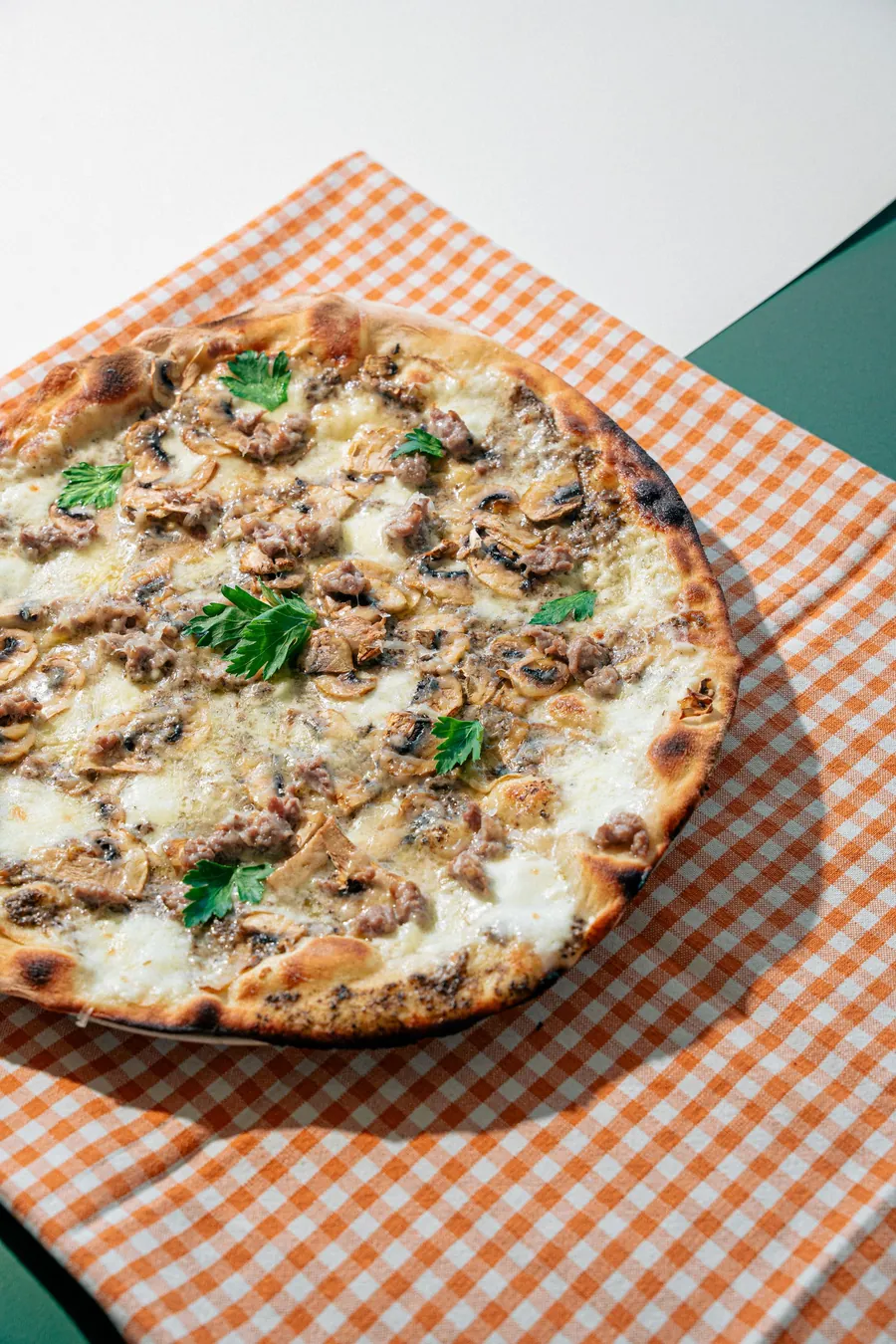 Pizza ai funghi su tovaglia a quadretti arancio
