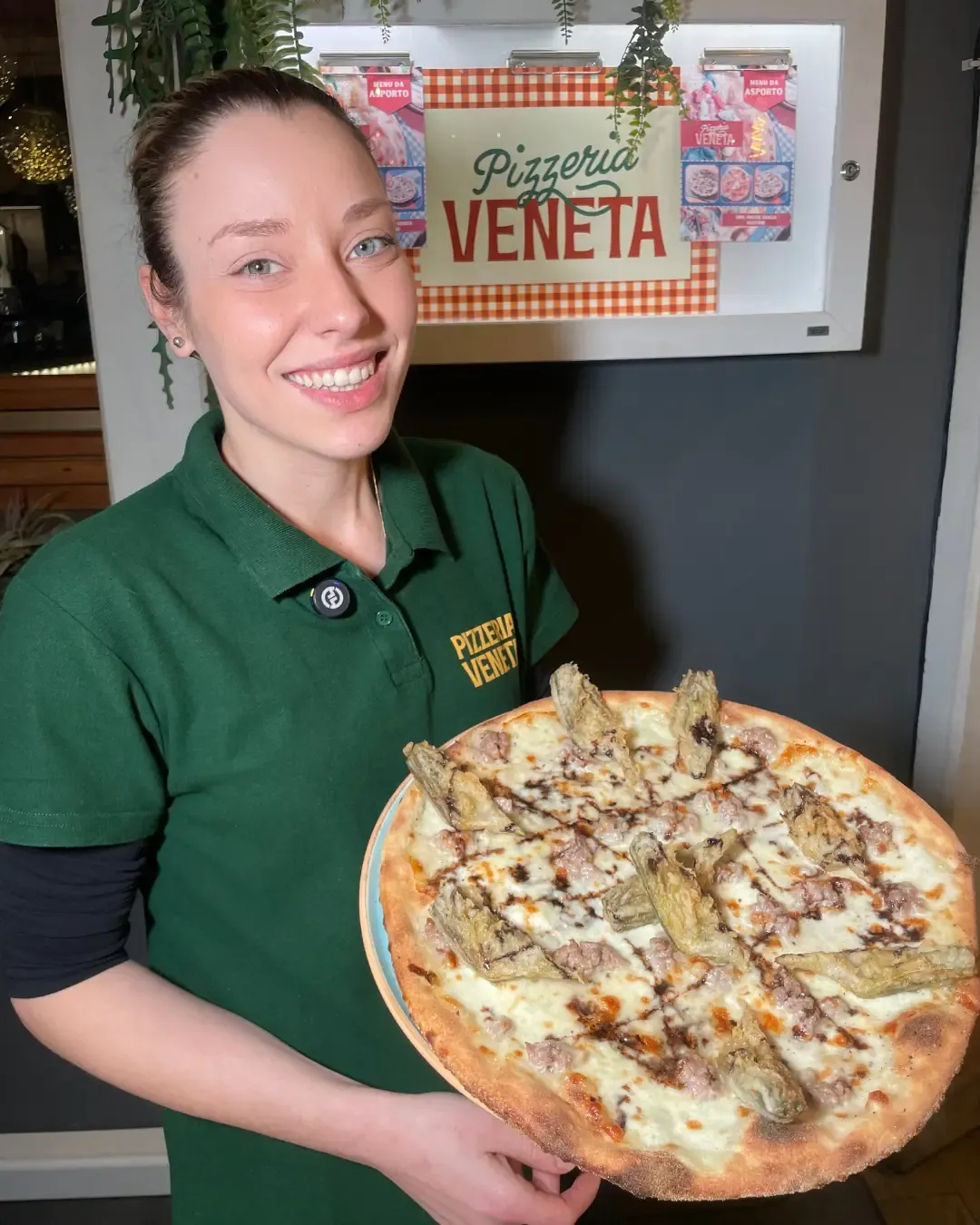 Lo staff di sala della Pizzeria Veneta davanti all'insegna