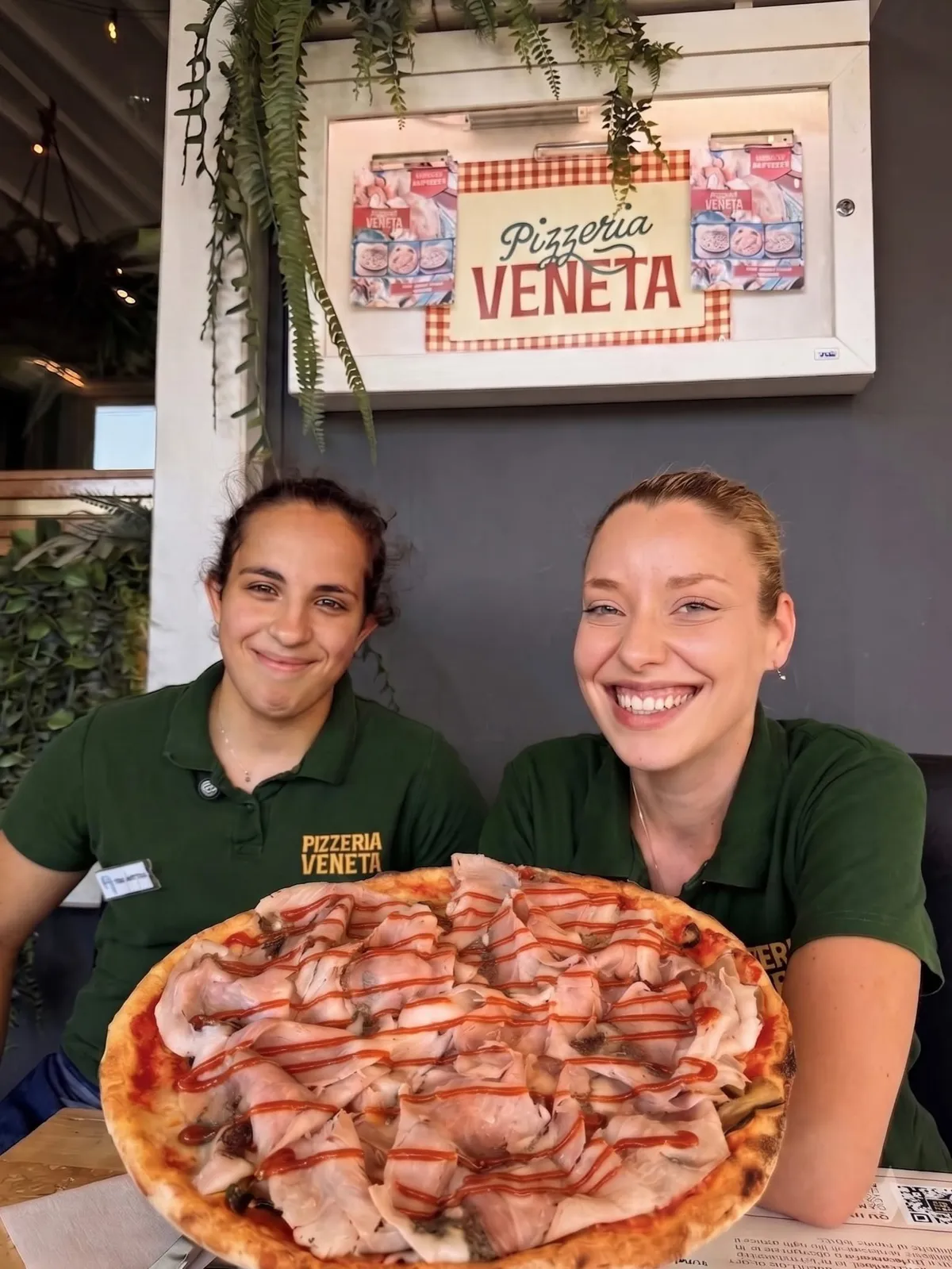 Due ragazze dello staff di sala della Pizzeria Veneta con una pizza in mano